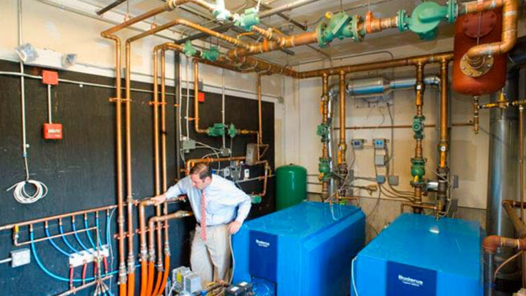 Control room for floor heating with worker for scale. 